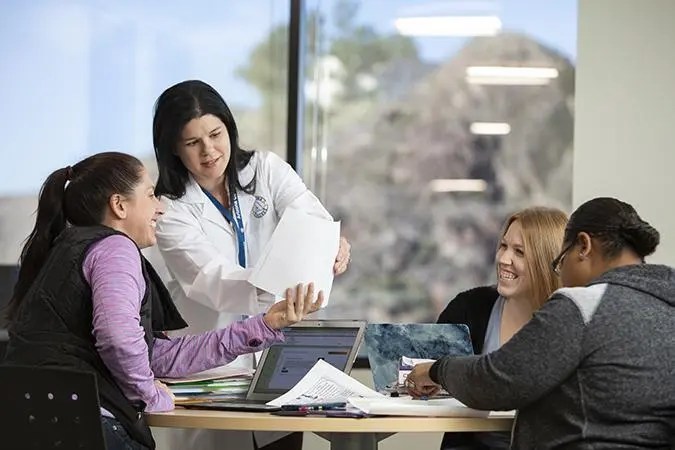 Nursing school faculty with students discussing BSN Program options.